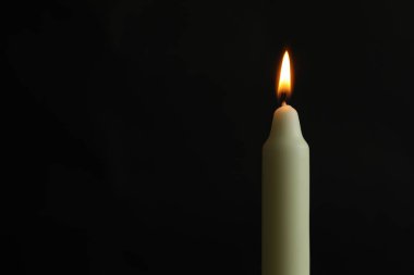 Siyah arkaplanda yanan bir kilise mumu, metin için boşluk