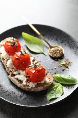 Lezzetli ricotta bruschetta, güneşte kurutulmuş domates, sos, fesleğen ve öğütülmüş biber, yakın plan.