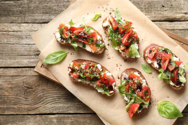 Lezzetli ricotta bruschetta domatesli, roka ve fesleğenli ahşap masa, üst manzara