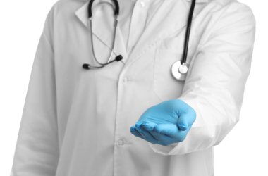 Doktor beyaz arka planda bir şey tutuyor, yakın plan.