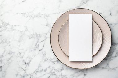 Boş menü ve tabaklar beyaz mermer masa, üst görünüm. Tasarım için model