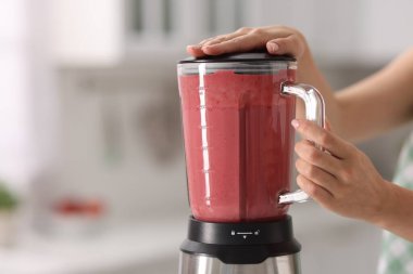 Mutfakta blender ile nefis smoothie yapan kadın, yakın plan. Metin için boşluk
