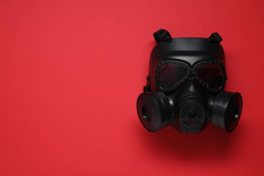 Kırmızı arka planda bir gaz maskesi, üst manzara. Metin için boşluk