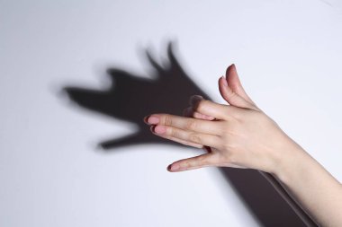 Gölge kuklası. Kadın arka plandaki köpek gibi el hareketi yapıyor, yakın plan. Metin için boşluk