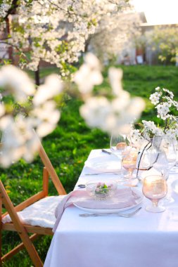 Bahçede güzel bahar çiçekleri olan şık bir masa.