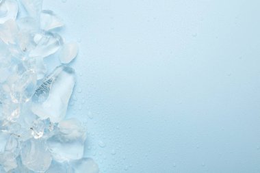 Açık mavi arka planda ezilmiş buz parçaları, üst manzara. Metin için boşluk
