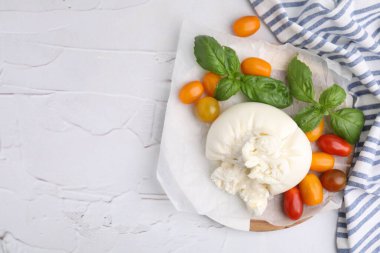 Lezzetli taze burrata peyniri fesleğen yaprağı ve domatesli beyaz desenli masa, düz yatak. Metin için boşluk