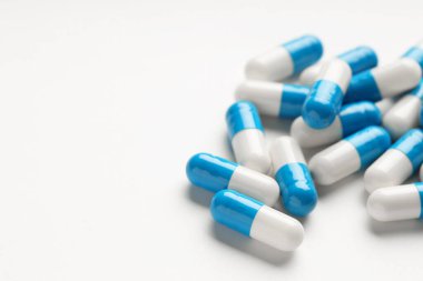 Beyaz arka planda antibiyotik haplar, yakın plan. Metin için boşluk