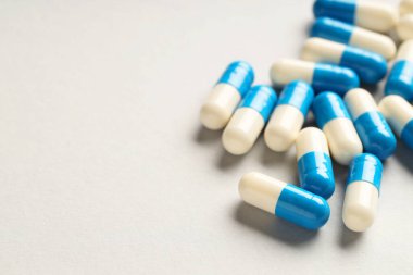 Gri arka planda bir sürü antibiyotik hapı, yakın plan ve mesaj için yer. Tıbbi tedavi