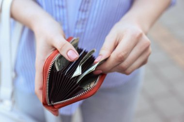 Dışarıda banknotları olan el çantası tutan kadın, yakın plan.