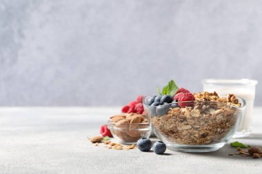 Böğürtlenli, fındıklı ve gri masada nane aromalı granola. Metin için boşluk