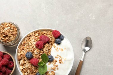 Gri desenli masada servis edilen meyveli ve yoğurtlu lezzetli granola. Metin için boşluk