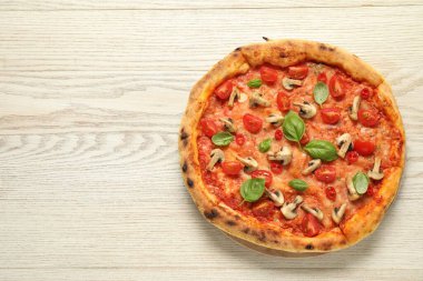 Domatesli, mantarlı ve ahşap masadaki fesleğenli leziz pizza. Metin için boşluk