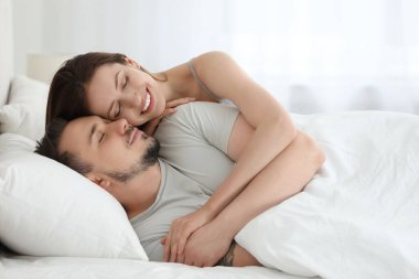 Mutlu çift evde yatakta eğleniyor.