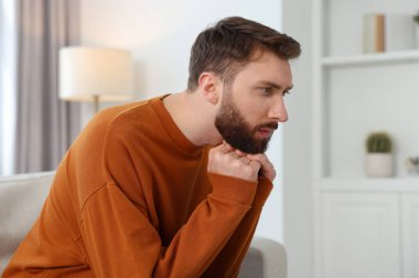 Yalnızlık kavramı. Evdeki kanepede oturan üzgün adam.