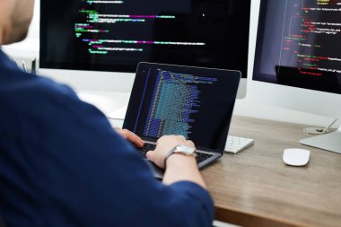Ofiste dizüstü bilgisayarla çalışan programcı, kapat