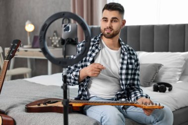 Müzik blogcusu evde akıllı telefon ve halka lambasıyla gitar dersi kaydediyor