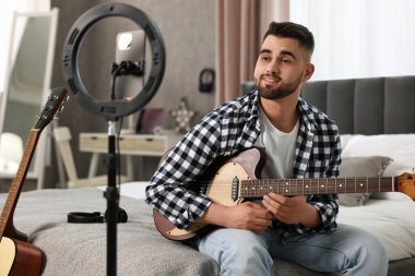 Müzik blogcusu evde akıllı telefon ve halka lambasıyla gitar dersi kaydediyor