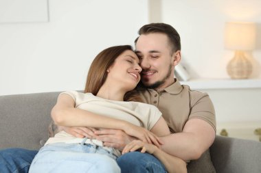 Mutlu çift evde kanepede sarılma