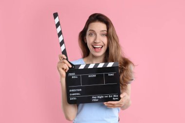 Film çekiyoruz. Pembe arka planda alkışları olan heyecanlı kadın.