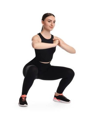 Beyaz arka plan üzerinde aerobik egzersiz yapan genç bir kadın.