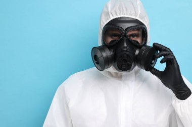 Açık mavi arka planda gaz maskeli bir işçi. Metin için boşluk