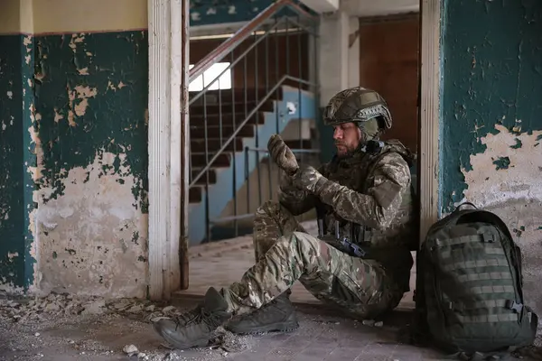 stock image Military mission. Soldier in uniform with drone controller inside abandoned building