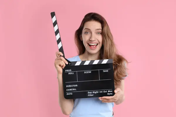 Stock image Making movie. Excited woman with clapperboard on pink background