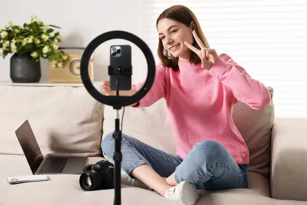 stock image Technology blogger recording video with smartphone and ring lamp at home