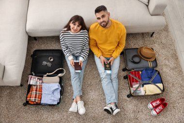 Pasaportları ve biletleri olan çift valizlerin yanında, içeride, en üst katta.