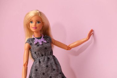 Mykolaiv, Ukrayna - 4 Eylül 2023: Mor arka planda kolye takan güzel Barbie bebek, metin için yer