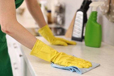 Mutfakta üniforma giyen profesyonel hademe tezgahı temizliyor.