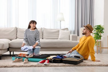 Evde yere inmek için bavul hazırlayan çift.