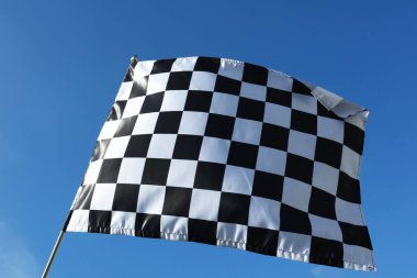 Mavi gökyüzünde kareli bayrak, alçak açı. Metin için boşluk