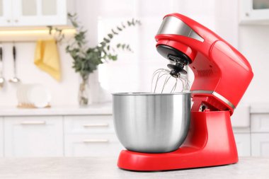 Mutfakta açık gri masa üzerinde modern kırmızı stand karıştırıcısı, metin için boşluk