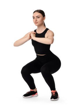 Beyaz arka plan üzerinde aerobik egzersiz yapan genç bir kadın.