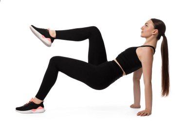 Beyaz arka plan üzerinde aerobik egzersiz yapan genç bir kadın.