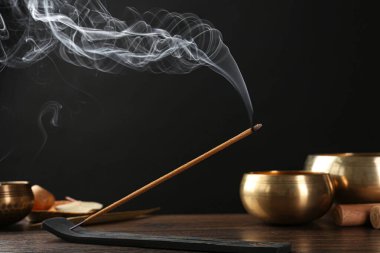 Aromatik tütsü, ahşap masa üzerinde Om işaretleri olan tutacakta için için için yanan çubuk.