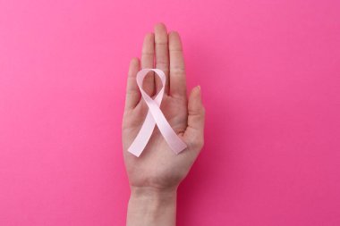 Pembe arka planda farkındalık kurdelesi olan kadın, üst görünüm