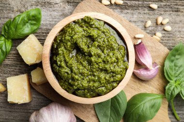 Lezzetli pesto sosu, fesleğen, çam fıstığı, peynir ve sarımsak ahşap masada.