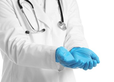 Doktor beyaz arka planda bir şey tutuyor, yakın plan.