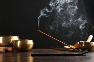 Aromatik tütsü, ahşap masa üzerinde Om işaretleri olan tutacakta için için için yanan çubuk.