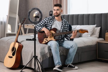 Müzik blogcusu evde akıllı telefon ve halka lambasıyla gitar dersi kaydediyor
