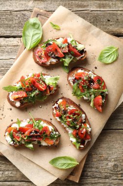 Lezzetli ricotta bruschetta domatesli, roka ve fesleğenli ahşap masa, üst manzara