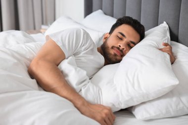 Sabahları yatakta uyuyan yakışıklı adam.
