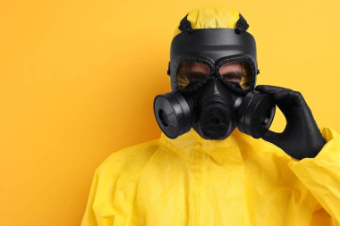 Sarı arka planda gaz maskeli bir işçi. Metin için boşluk