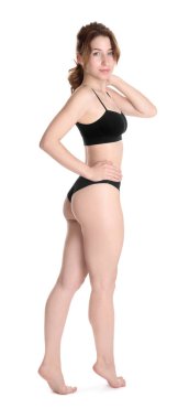 Beyaz arka planda poz veren ince vücutlu kadın.