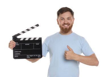 Film çekiyoruz. Clapperboard 'lu gülümseyen adam beyaz arka planda başparmağını gösteriyor.