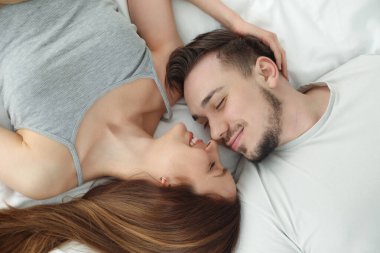 Güzel bir çiftin aile portresi. Yatakta, üst tarafta.
