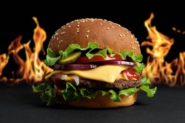 Karanlık masada nefis bir burger aleve karşı.